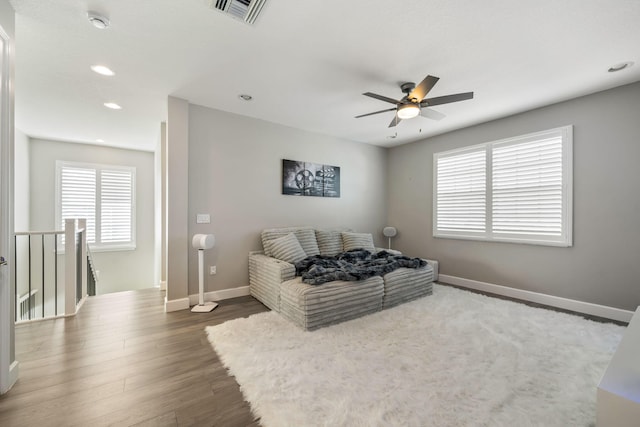 living room with baseboards, visible vents, wood finished floors, and recessed lighting