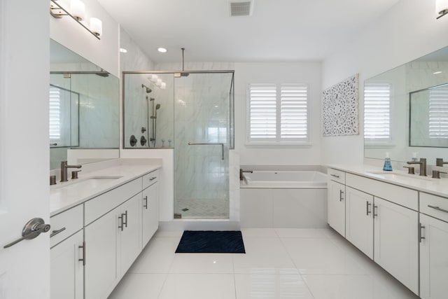 full bathroom with visible vents, a sink, a shower stall, and a garden tub