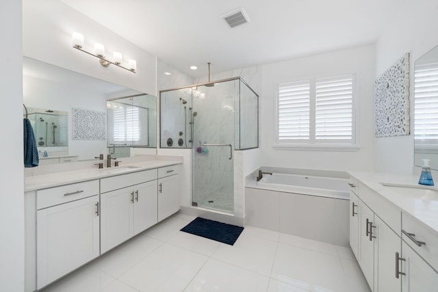 bathroom featuring a stall shower, visible vents, two vanities, and a sink