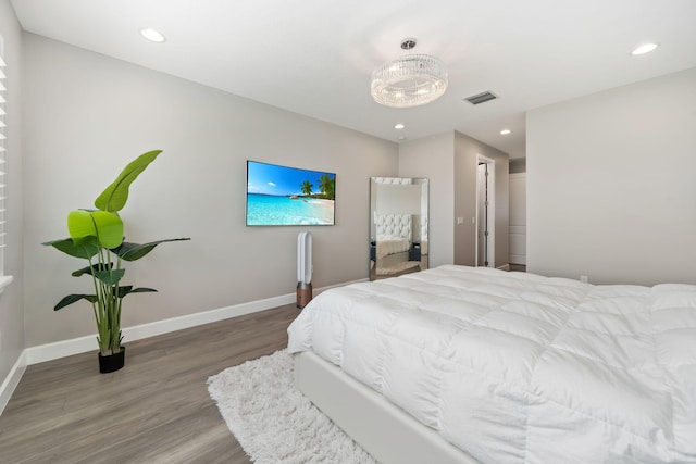 bedroom with visible vents, baseboards, wood finished floors, and recessed lighting