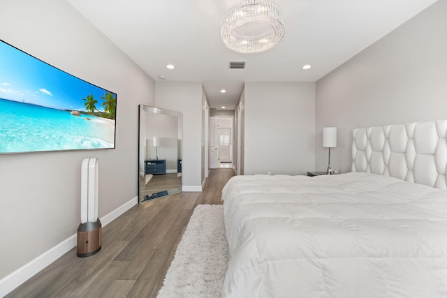 bedroom featuring recessed lighting, wood finished floors, visible vents, baseboards, and an inviting chandelier