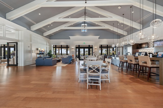 dining area with visible vents, beamed ceiling, wood finished floors, and french doors