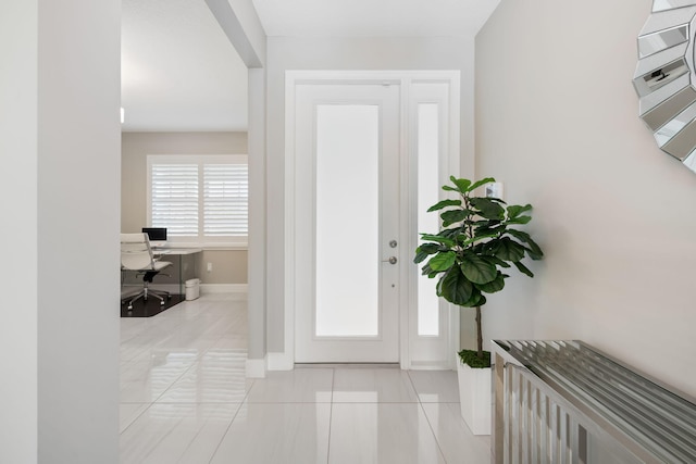 entryway with light tile patterned floors and baseboards