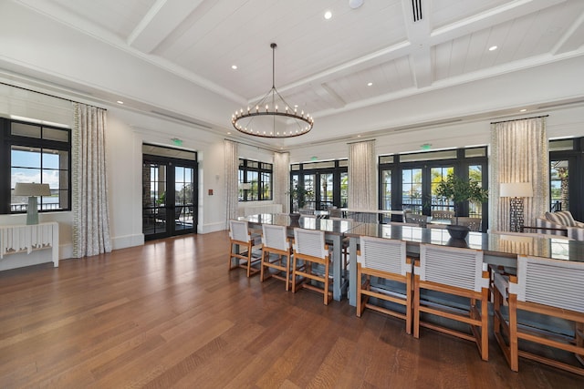 dining space with an inviting chandelier, beam ceiling, wood finished floors, and french doors