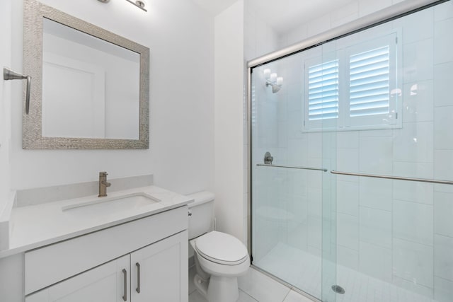 bathroom featuring vanity, toilet, and a shower stall
