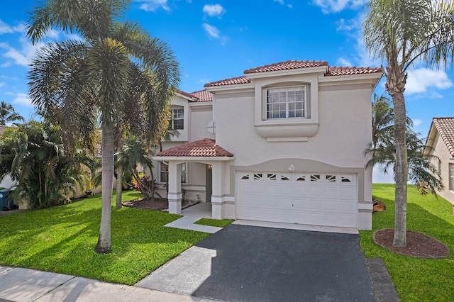 mediterranean / spanish-style home with driveway, a tile roof, an attached garage, a front lawn, and stucco siding