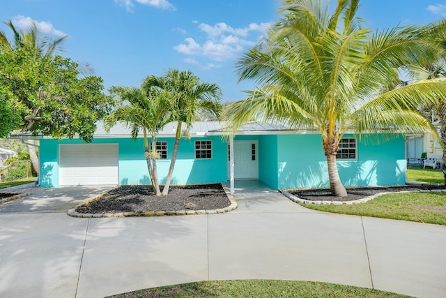 single story home featuring concrete driveway, an attached garage, and stucco siding