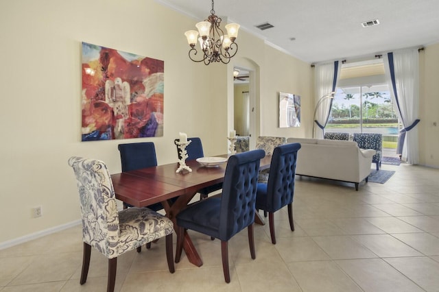 dining room featuring light tile patterned floors, baseboards, visible vents, arched walkways, and ornamental molding