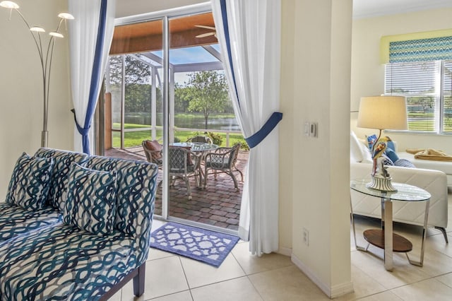 living area featuring light tile patterned floors, a sunroom, and baseboards