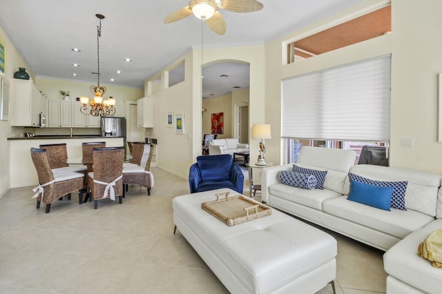 living room with arched walkways, light tile patterned floors, recessed lighting, ceiling fan with notable chandelier, and baseboards