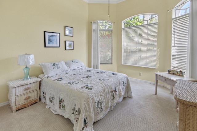 bedroom with light carpet, baseboards, and ornamental molding