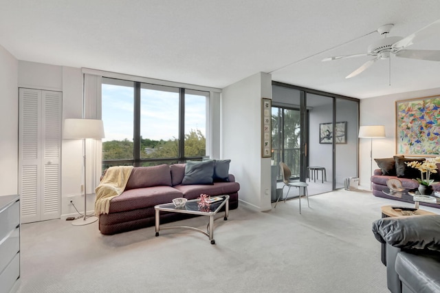 living area with light carpet, ceiling fan, and floor to ceiling windows