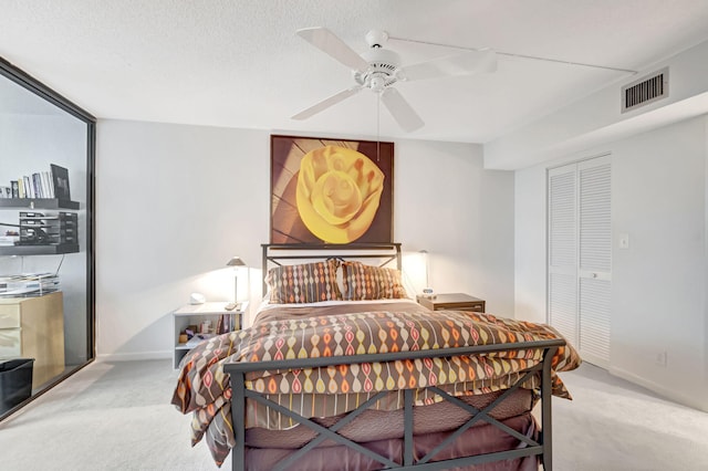 carpeted bedroom with visible vents, baseboards, ceiling fan, a textured ceiling, and a closet