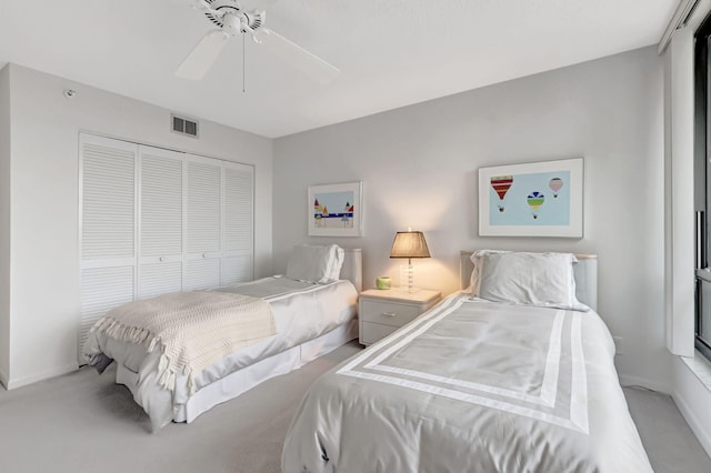 bedroom featuring baseboards, visible vents, light colored carpet, ceiling fan, and a closet