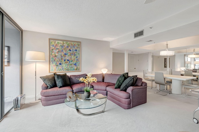 carpeted living area featuring a textured ceiling and visible vents