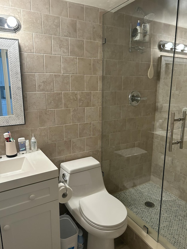 bathroom featuring toilet, a shower stall, and vanity