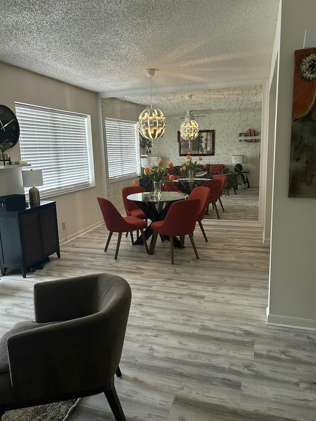 dining area with a textured ceiling, an inviting chandelier, wood finished floors, and baseboards