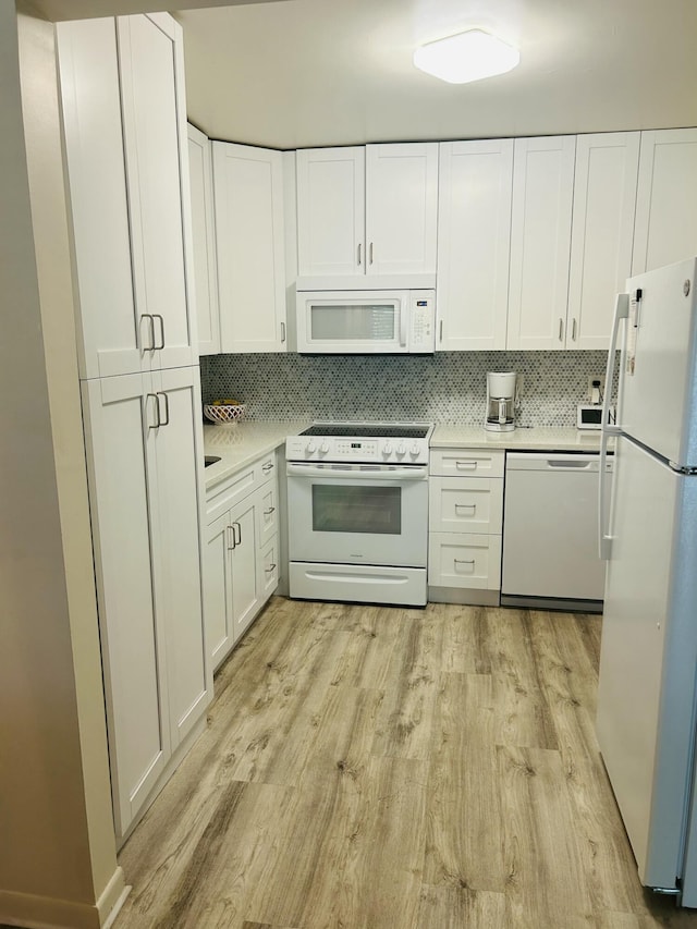 kitchen featuring white appliances, white cabinetry, light countertops, and light wood finished floors