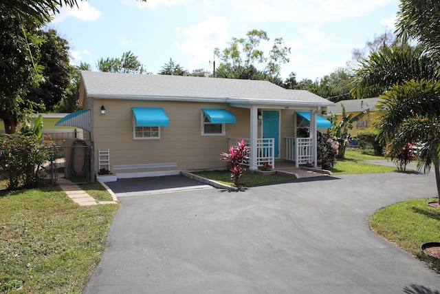 view of front of house with aphalt driveway and a front yard