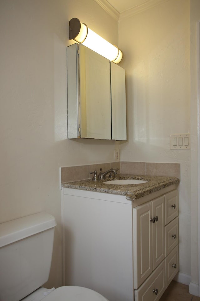 half bathroom with toilet, vanity, and crown molding