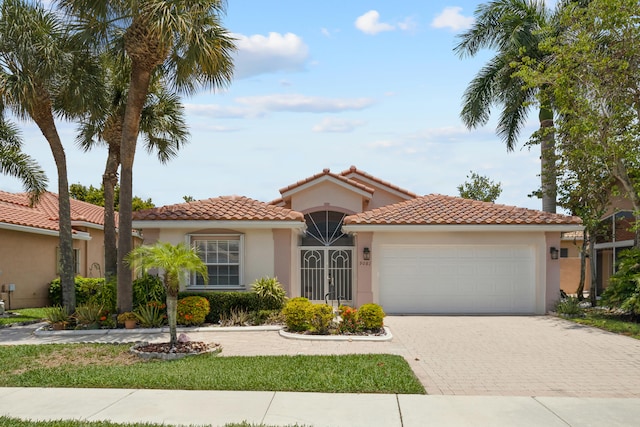 9081 Livorno St, Boynton Beach, FL 33472 - mediterranean / spanish home featuring a garage, stucco siding, driveway, and a tile roof