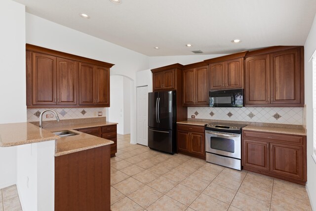 9081 Livorno St, Boynton Beach, FL 33472 - kitchen with black appliances, a sink, a peninsula, backsplash, and arched walkways