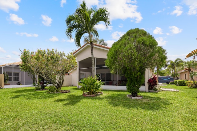 9081 Livorno St, Boynton Beach, FL 33472 - rear view of property with a sunroom, a lawn, a tiled roof, and stucco siding