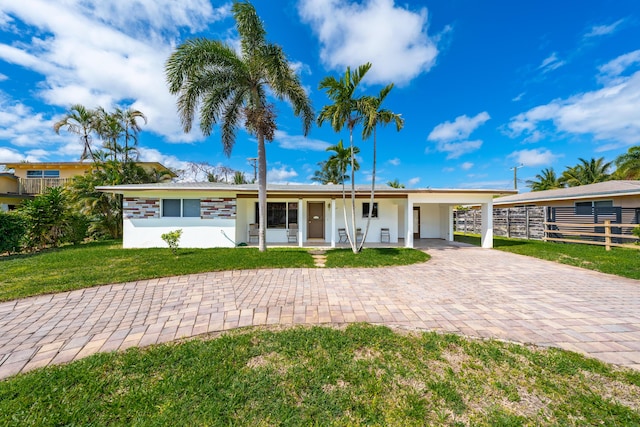 ranch-style house featuring fence, a carport, and a front yard