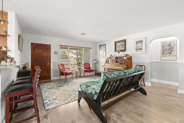 living area with baseboards and wood finished floors