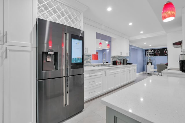 kitchen featuring decorative backsplash, stainless steel fridge with ice dispenser, white cabinetry, pendant lighting, and a sink