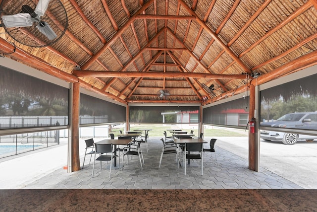 view of patio with ceiling fan, a gazebo, outdoor dining space, and fence