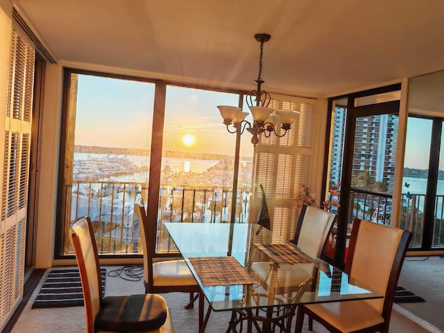 carpeted dining area with floor to ceiling windows and an inviting chandelier