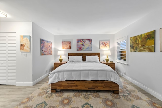 bedroom featuring light wood-style floors and baseboards