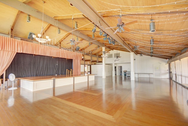 interior space with beam ceiling, wood finished floors, and ceiling fan with notable chandelier