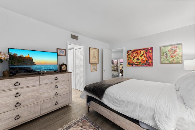 bedroom with dark wood-style floors and visible vents