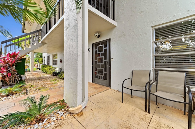 view of exterior entry featuring a patio and stucco siding