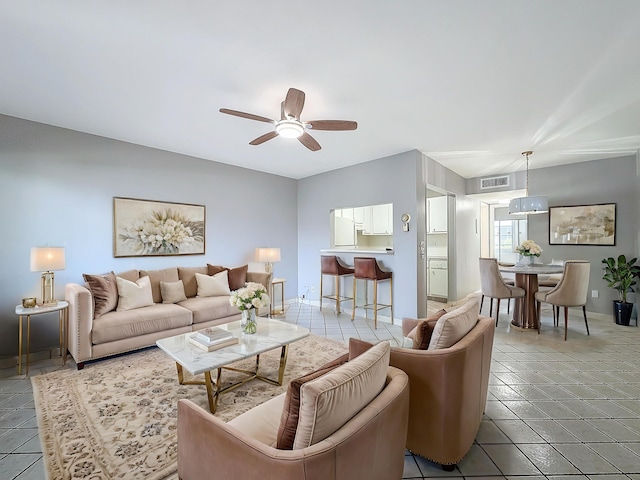 living room with a ceiling fan, visible vents, baseboards, and light tile patterned floors