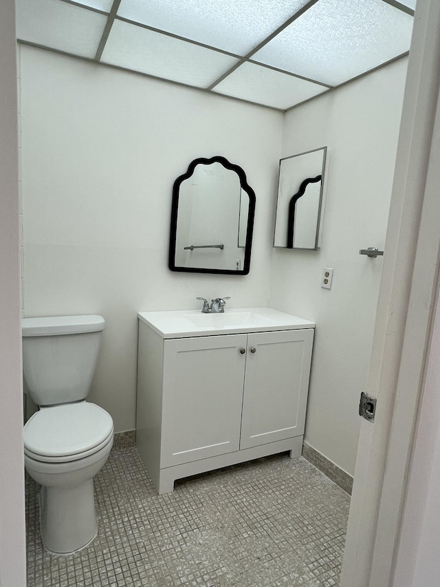 bathroom with toilet, baseboards, and vanity