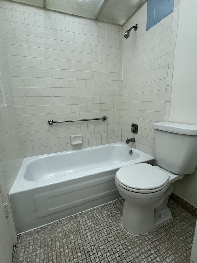 full bath featuring tile patterned flooring, bathtub / shower combination, toilet, and baseboards