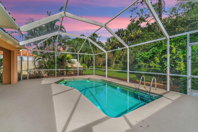 pool at dusk featuring glass enclosure, a patio area, fence, and an outdoor pool