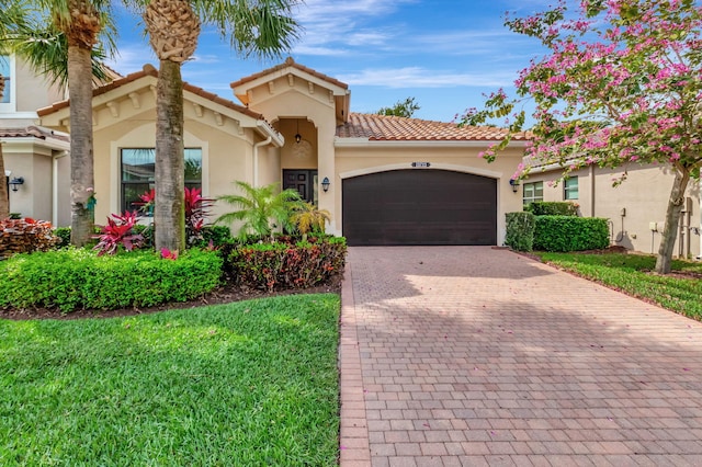 mediterranean / spanish home featuring a tiled roof, decorative driveway, an attached garage, and stucco siding