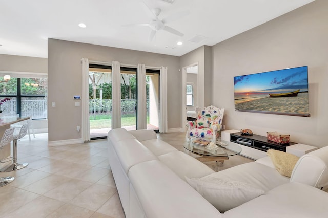 living room featuring baseboards, a wealth of natural light, and recessed lighting