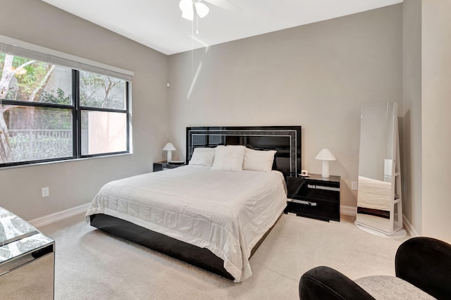 bedroom featuring a ceiling fan, light colored carpet, and baseboards