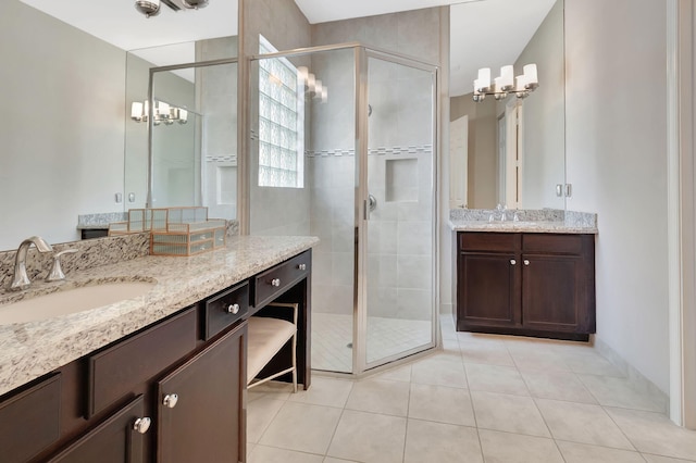 bathroom featuring two vanities, a sink, tile patterned flooring, and a shower stall