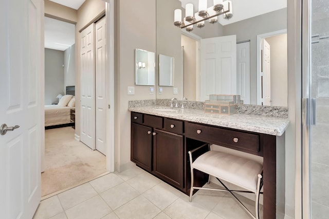 ensuite bathroom featuring a chandelier, tile patterned flooring, vanity, a closet, and ensuite bath