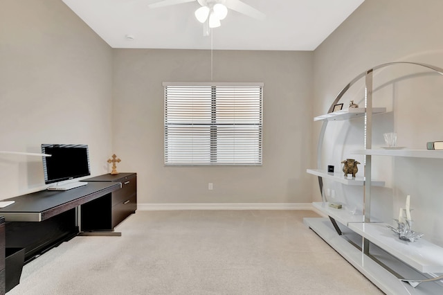 office featuring a ceiling fan, light carpet, and baseboards