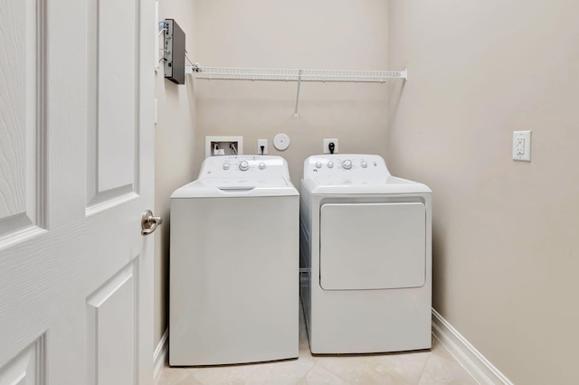 washroom with laundry area, independent washer and dryer, light tile patterned flooring, and baseboards