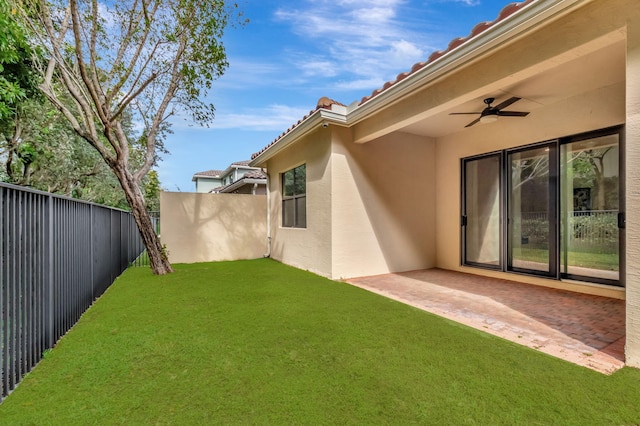 view of yard with a patio area, fence, and a ceiling fan