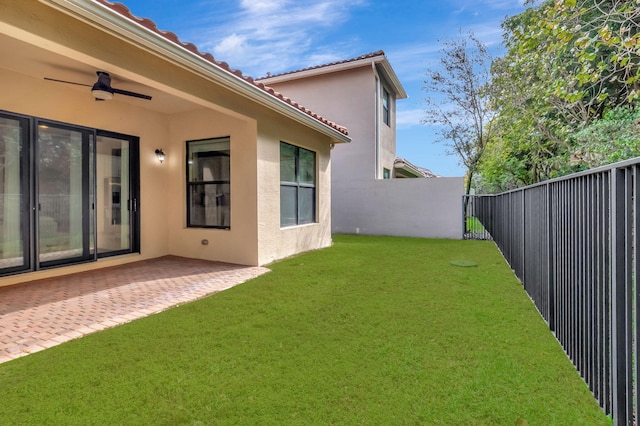 view of yard featuring a patio area, a fenced backyard, and ceiling fan