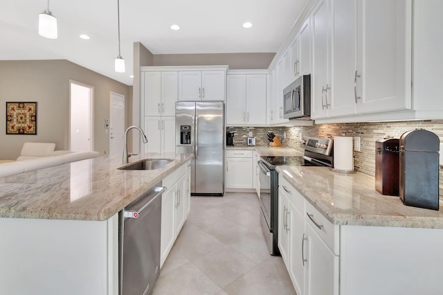 kitchen with appliances with stainless steel finishes, decorative light fixtures, and white cabinetry